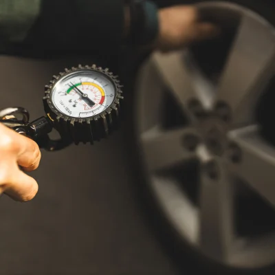 A car mechanic checks the pressure in the car's tires